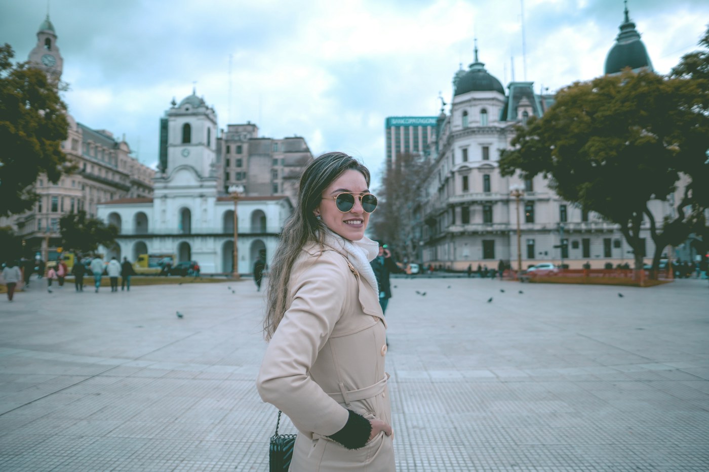 Woman wearing a pale puffer jacket in a city square