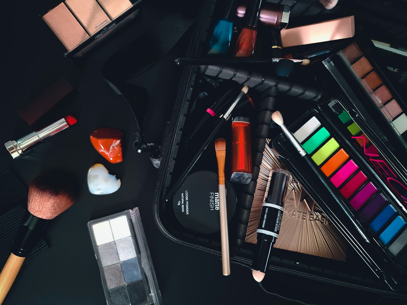 Cosmetics and makeup brushes spread on a table