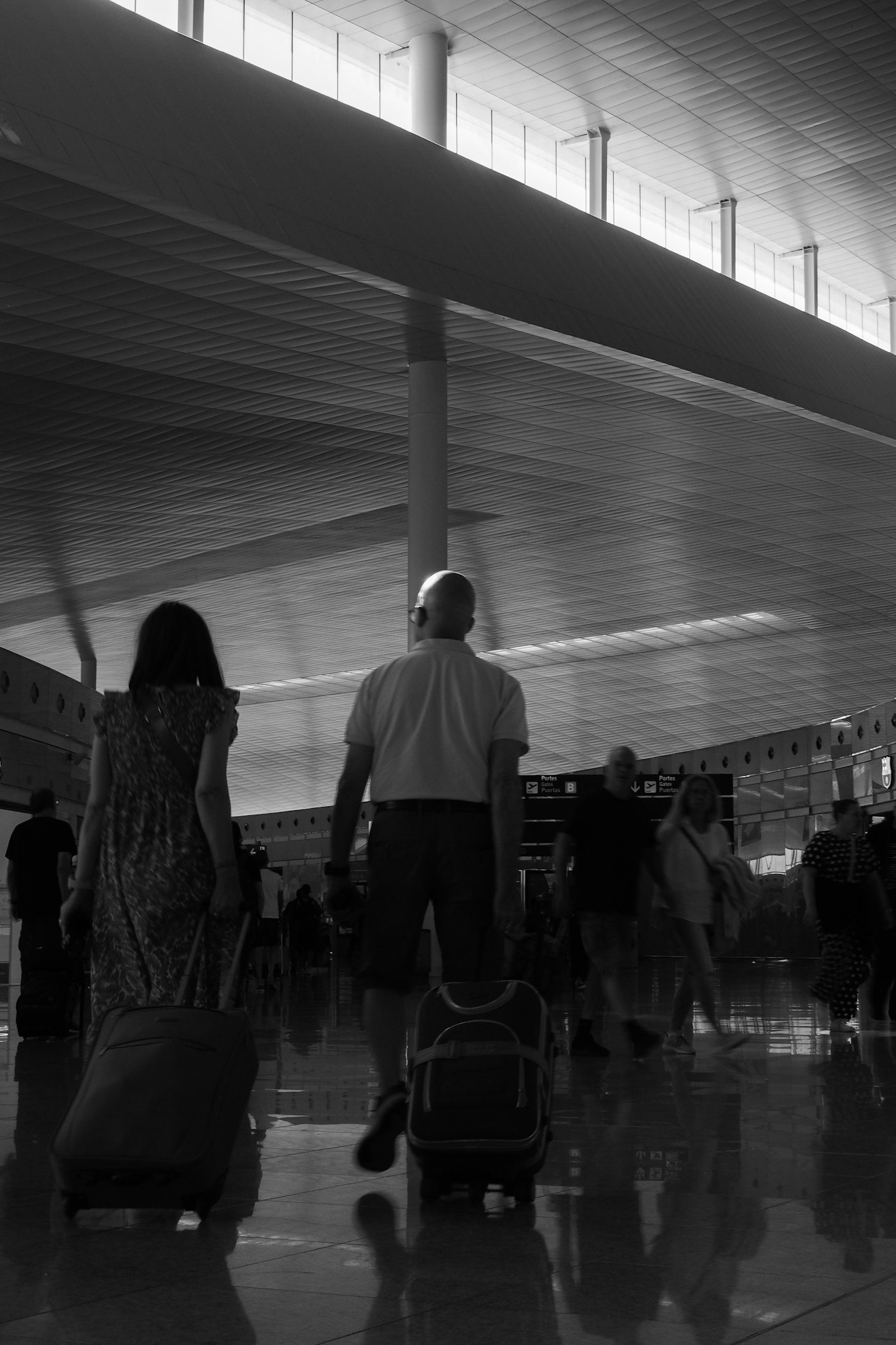 People walking with suitcases in a modern terminal